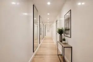 découvrez comment transformer un couloir long et étroit en un espace lumineux et accueillant, sans avoir besoin de percer de fenêtres, grâce à des astuces de décoration et d'éclairage efficaces.